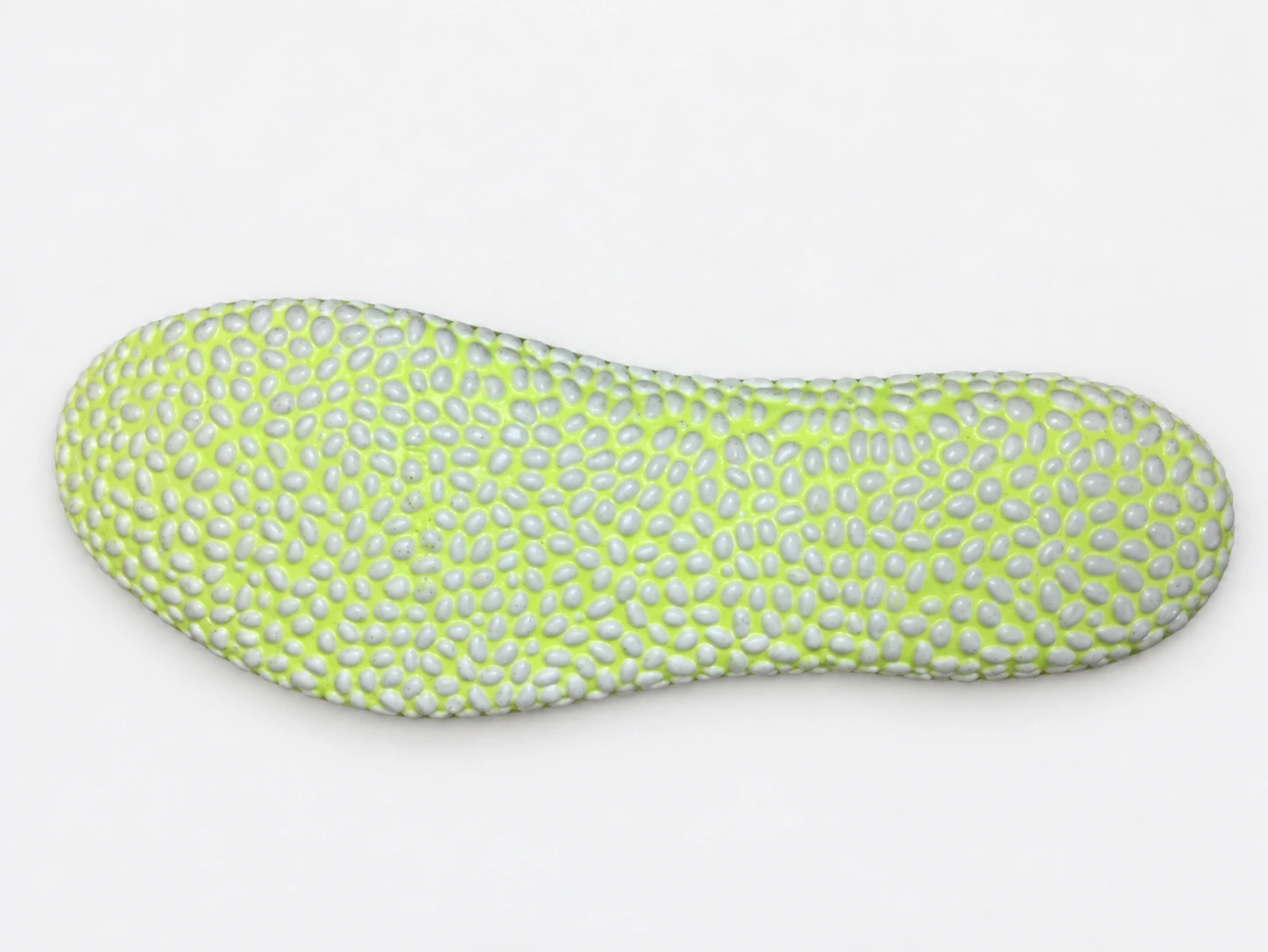 Complete Innovtech insole sample with small grey TPU bubbles in a yellow-green cushioning material, cleaned onto a neutral background